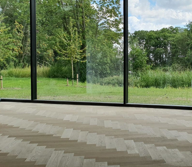 Elleboog patroon eiken houten vloer met bosrijke omgeving als achtergrond