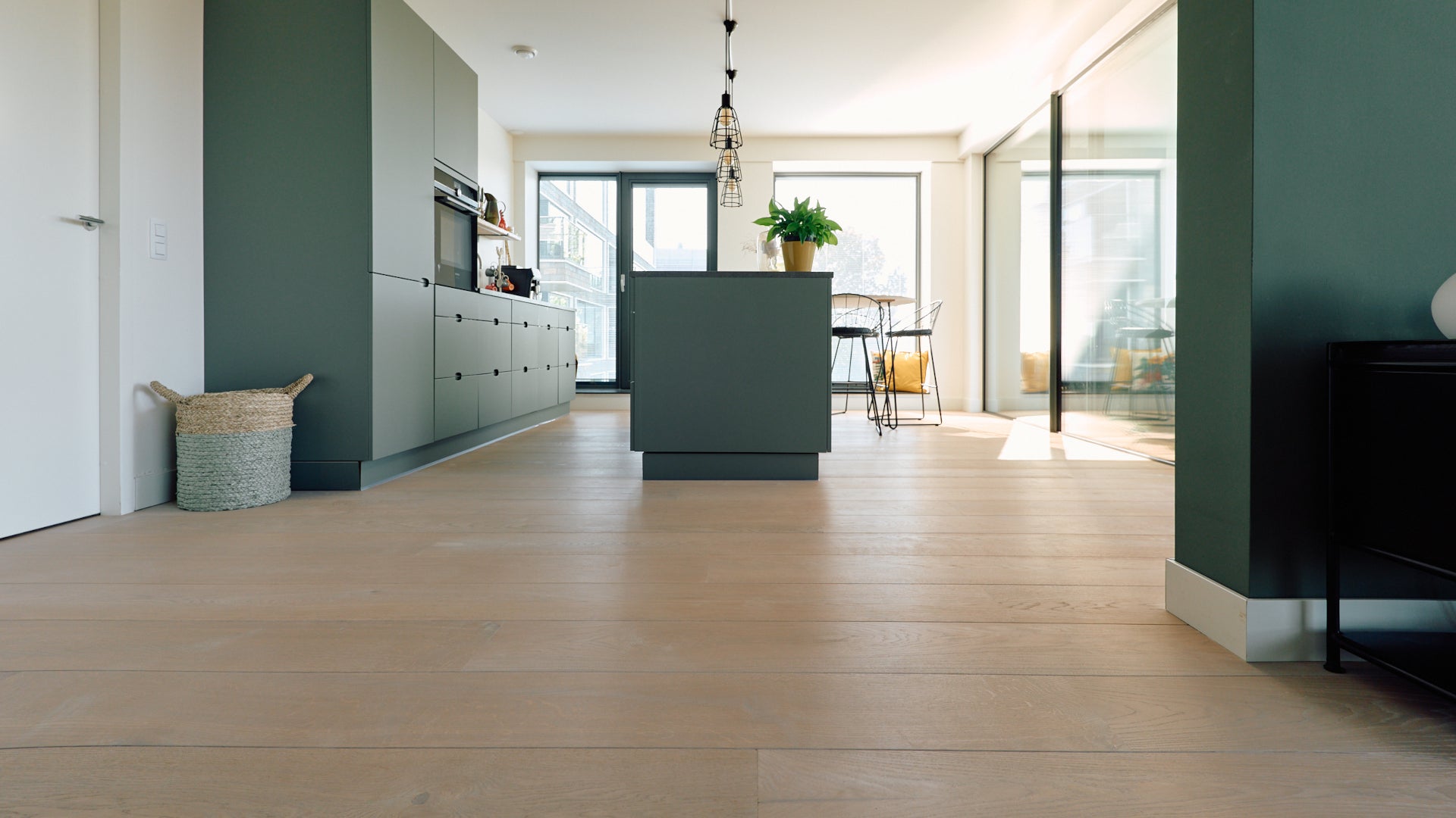 Brede planken vloer gelegd door Uipkes in de keuken en woonkamer van een modern ingerichte woning