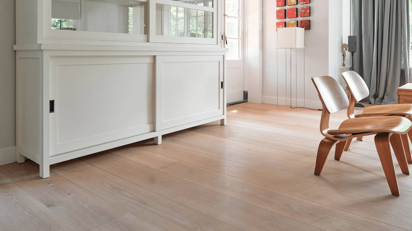 Eiken vloer op vloerverwarming in een woonkamer in Hilversum in de kleur Mondriaan Wit met 280mm brede planken.