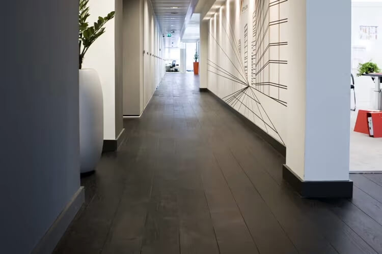 De donkere houten vloer is gelegd in een kantoorpand in Amsterdam 