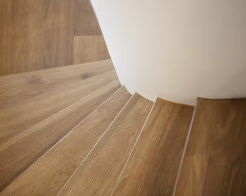 Wenteltrap van hout waarbij dezelfde kleur treden als de vloer zijn gebruikt